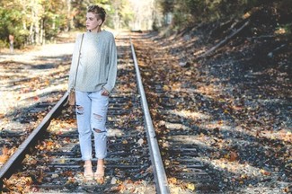 Light Blue Ripped Jeans Outfits For Women: A grey cable sweater and light blue ripped jeans paired together are a total eye candy for those dressers who love relaxed styles. A pair of white leather heeled sandals easily steps up the oomph factor of your getup.