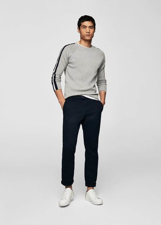 Grey Crew-neck Sweater with Chinos Casual Spring Outfits: The styling capabilities of a grey crew-neck sweater and chinos ensure you'll always have them on heavy rotation. Why not introduce a pair of white leather low top sneakers to your outfit for a hint of stylish nonchalance? This is a never-failing option for a knockout outfit that will take you from winter to spring.