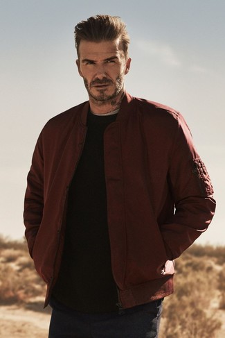David Beckham wearing Navy Chinos, Grey Crew-neck T-shirt, Black Crew-neck Sweater, Burgundy Bomber Jacket