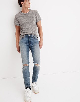 Blue Ripped Jeans Outfits For Men: A grey crew-neck t-shirt and blue ripped jeans are a go-to casual combination for many trendsetting gentlemen. A pair of white and blue leather low top sneakers immediately spruces up any ensemble.
