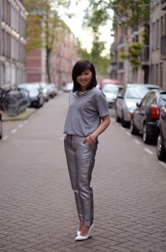 Grey Tapered Pants Outfits For Women: You're looking at the irrefutable proof that a grey crew-neck t-shirt and grey tapered pants look awesome when married together in a casual ensemble. A pair of white leather wedge pumps makes this ensemble whole.