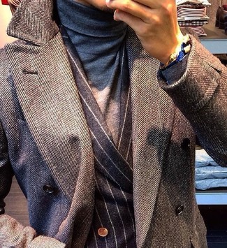 This combination of a grey herringbone overcoat and a charcoal vertical striped double breasted blazer embodies sophistication and versatility.