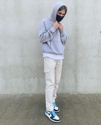 Beige Cargo Pants Outfits: This combination of a grey hoodie and beige cargo pants is hard proof that a safe off-duty outfit doesn't have to be boring. All you need now is a cool pair of white and navy leather low top sneakers to complete your outfit.