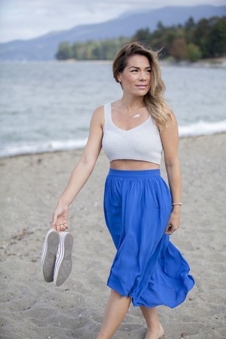Blue Pleated Midi Skirt with Sneakers Outfits: This combo of a grey knit cropped top and a blue pleated midi skirt is the perfect foundation for a chic ensemble. A pair of sneakers will bring a carefree touch to your outfit.