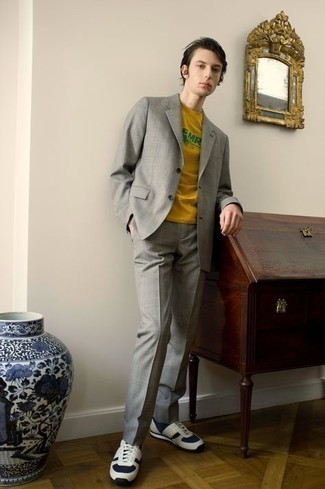 Grey Suit Casual Outfits: This ensemble shows it is totally worth investing in such menswear essentials as a grey suit and a mustard print crew-neck t-shirt. A trendy pair of navy and white athletic shoes is an easy way to bring a dose of stylish nonchalance to your outfit.