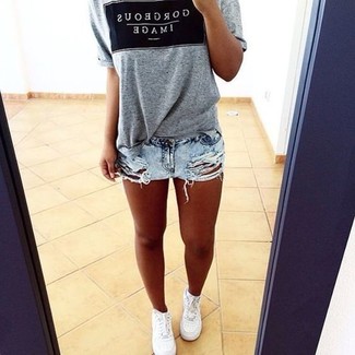 Charcoal Print Crew-neck T-shirt Outfits For Women: Want to infuse your wardrobe with some edgy cool? Wear a charcoal print crew-neck t-shirt and light blue ripped denim shorts. White low top sneakers integrate smoothly within a variety of combos.