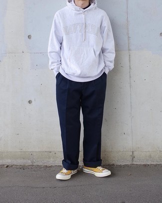 Yellow Canvas Low Top Sneakers Outfits For Men: This combo of a grey print hoodie and navy chinos resonates laid-back attitude and stylish practicality. If not sure about the footwear, complete your outfit with yellow canvas low top sneakers.
