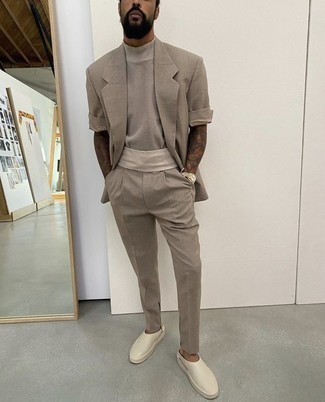 Grey Suit Outfits: For relaxed refinement with a manly finish, wear a grey suit with a grey crew-neck t-shirt. Rock a pair of white leather loafers for an added touch of class.