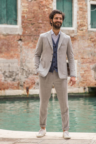 Navy Sweater Vest Outfits For Men: Try pairing a navy sweater vest with a grey suit for devastatingly stylish attire. Feeling transgressive? Shake things up with white canvas low top sneakers.