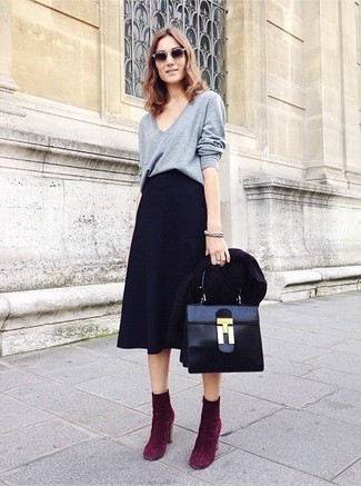 Marry a grey v-neck sweater with a black midi skirt and you'll be ready for wherever this day takes you. Complement this look with purple suede ankle boots to instantly turn up the chic factor of any look.