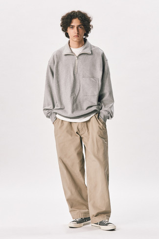 Charcoal Canvas Low Top Sneakers Outfits For Men: This casual combination of a grey zip neck sweater and khaki chinos is perfect if you want to feel confident in your look. When this ensemble looks all-too-dressy, play it down by sporting a pair of charcoal canvas low top sneakers.