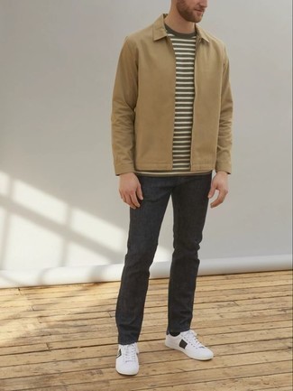 White and Black Canvas Low Top Sneakers Outfits For Men: For an on-trend look without the need to sacrifice on comfort, we love this combo of a tan harrington jacket and charcoal jeans. The whole look comes together brilliantly if you add a pair of white and black canvas low top sneakers to the equation.