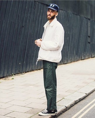 Dark Green Jeans Outfits For Men: Why not team a white harrington jacket with dark green jeans? Both pieces are super functional and will look awesome when worn together. Black and white canvas low top sneakers are a welcome addition for your outfit.