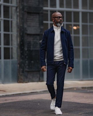 Blue Vertical Striped Chinos Outfits: For an outfit that brings function and style, choose a navy harrington jacket and blue vertical striped chinos. White canvas low top sneakers pull the getup together.