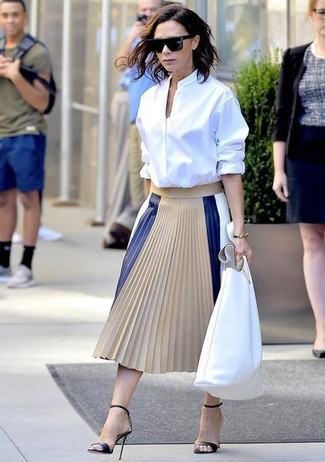 Victoria Beckham wearing White Leather Tote Bag, Black Leather Heeled Sandals, Beige Pleated Leather Midi Skirt, White Dress Shirt