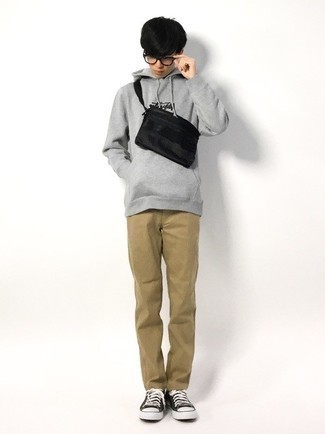Black Canvas Fanny Pack Outfits For Men: If you're in search of a casual street style and at the same time dapper look, marry a grey print hoodie with a black canvas fanny pack. Balance this look with a more elegant kind of shoes, like this pair of black and white canvas low top sneakers.