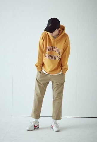Tobacco Print Hoodie Outfits For Men: This laid-back combo of a tobacco print hoodie and khaki chinos is a lifesaver when you need to look neat and relaxed but have no extra time. On the footwear front, this look is finished off really well with white and red leather low top sneakers.