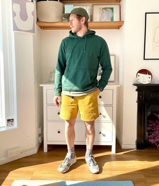 Dark Green Hoodie Outfits For Men: A dark green hoodie and mustard sports shorts are great menswear staples that will integrate perfectly within your day-to-day routine. Beige athletic shoes will tie this whole getup together.