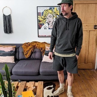 1200+ Relaxed Outfits For Men: You'll be amazed at how super easy it is for any guy to get dressed like this. Just a charcoal hoodie and charcoal sports shorts. Feeling inventive today? Jazz things up by rounding off with a pair of beige canvas slip-on sneakers.