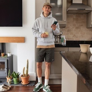 121 Relaxed Outfits For Men: If you're searching for a casual yet stylish outfit, marry a grey hoodie with dark green sports shorts. Complete your outfit with dark green athletic shoes et voila, the outfit is complete.