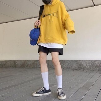 Mustard Print Hoodie Outfits For Men: For a surefire casual option, you can rely on this combo of a mustard print hoodie and black sports shorts. To bring out a classy side of you, add a pair of black and white canvas low top sneakers to the mix.