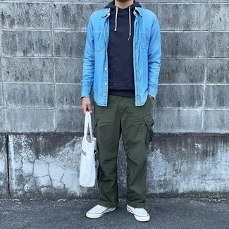 Men's Outfits 2021: For a winning casual option, you can never go wrong with this combo of a navy hoodie and olive cargo pants. We're totally digging how this whole look comes together thanks to white canvas low top sneakers.