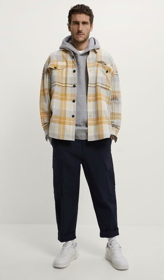 Grey Plaid Long Sleeve Shirt Outfits For Men: Such essentials as a grey plaid long sleeve shirt and navy cargo pants are the ideal way to inject subtle dapperness into your daily casual collection. Complement this outfit with a pair of white leather low top sneakers and off you go looking spectacular.