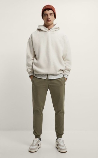 White Hoodie Outfits For Men: A white hoodie and olive chinos are a great ensemble that will take you throughout the day and into the night. A pair of white leather low top sneakers is a safe footwear option that's also full of personality.