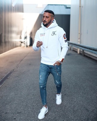 White and Black Print Hoodie Outfits For Men: This combination of a white and black print hoodie and blue ripped skinny jeans spells comfort and versatility. Don't know how to finish off your outfit? Rock a pair of white canvas low top sneakers to lift it up.