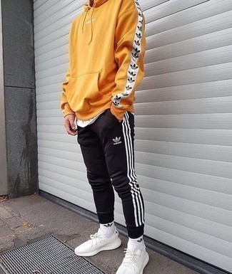 Mustard Hoodie Outfits For Men: A mustard hoodie and black sweatpants are the kind of a never-failing casual outfit that you need when you have zero time to spare. If not sure about the footwear, complete this look with white athletic shoes.