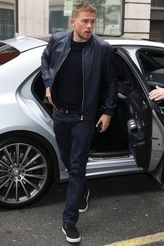 Charlie Hunnam wearing Black Low Top Sneakers, Navy Jeans, Black Crew-neck Sweater, Navy Leather Bomber Jacket