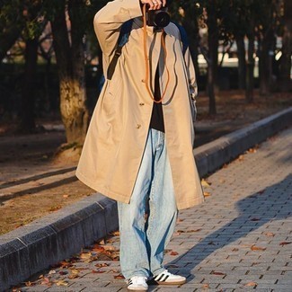 Men's White and Black Canvas Low Top Sneakers, Light Blue Jeans, Dark Brown Long Sleeve T-Shirt, Tan Trenchcoat