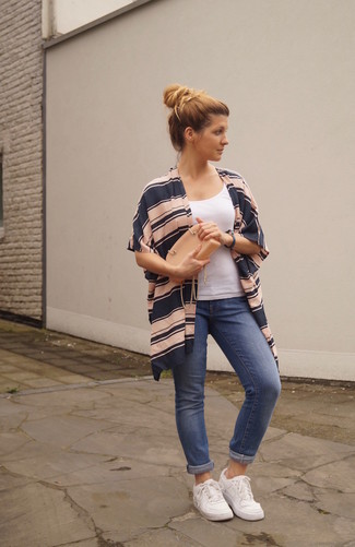 Tan Leather Clutch Outfits: A navy horizontal striped kimono and a tan leather clutch are a good combination to have in your casual styling repertoire. For extra fashion points, complement your ensemble with a pair of white low top sneakers.