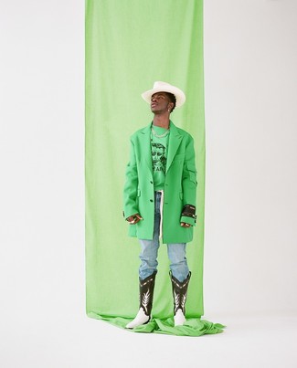 Lil Nas X wearing Black and White Leather Cowboy Boots, Light Blue Jeans, Green Print Sweatshirt, Green Overcoat