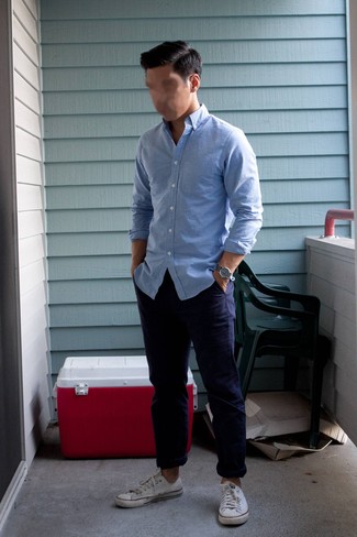 A light blue long sleeve shirt and navy chinos matched together are a perfect match. Rounding off with a pair of white low top sneakers is a fail-safe way to introduce an air of stylish nonchalance to this ensemble.