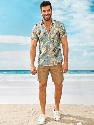 Light Blue Short Sleeve Shirt Outfits For Men: A light blue short sleeve shirt and tan shorts are a good combo to keep in your menswear arsenal. White canvas low top sneakers look right at home with this outfit.