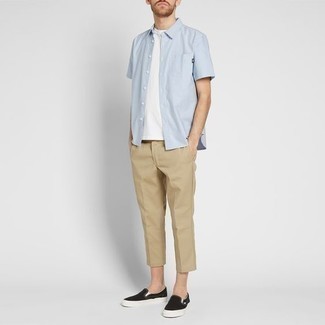 Black and White Canvas Slip-on Sneakers Outfits For Men: This is irrefutable proof that a light blue short sleeve shirt and khaki chinos look awesome together in a casual look. A pair of black and white canvas slip-on sneakers looks wonderful here.