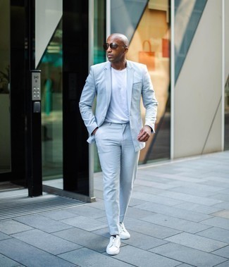 Light Blue Suit Outfits: Reach for a light blue suit and a white crew-neck t-shirt to assemble an interesting and pulled together ensemble. A pair of white canvas low top sneakers easily boosts the cool of this look.