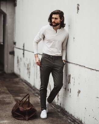 Tobacco Leather Duffle Bag Outfits For Men: A white long sleeve henley shirt and a tobacco leather duffle bag are an easy way to introduce some cool into your daily wardrobe. Add a pair of white canvas low top sneakers to the equation to easily amp up the fashion factor of any getup.