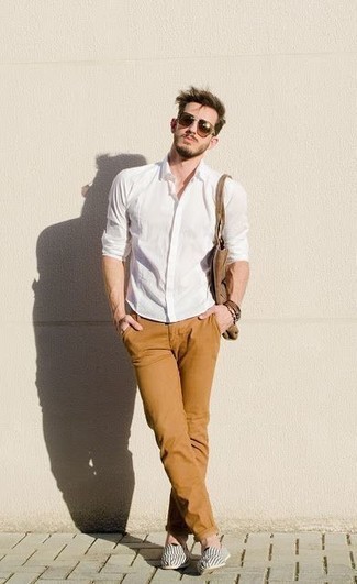White Canvas Espadrilles Outfits For Men: This relaxed casual combination of a white long sleeve shirt and tobacco chinos is very easy to throw together in no time flat, helping you look on-trend and prepared for anything without spending too much time combing through your closet. Add white canvas espadrilles to the mix and you're all done and looking dashing.