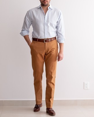 Light Blue Vertical Striped Long Sleeve Shirt Outfits For Men: For a casual outfit, opt for a light blue vertical striped long sleeve shirt and tobacco chinos — these pieces work really well together. Finishing with dark brown leather loafers is a guaranteed way to inject an added dose of refinement into this ensemble.