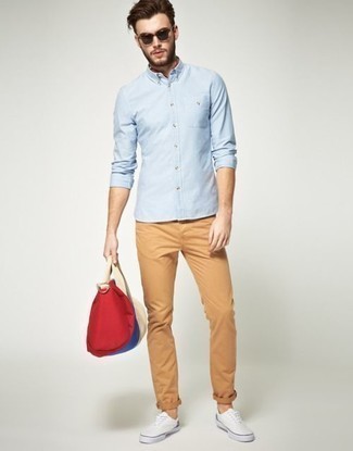 Multi colored Canvas Duffle Bag Outfits For Men: A light blue long sleeve shirt and a multi colored canvas duffle bag are the kind of a tested casual combo that you need when you have no time. White canvas low top sneakers are guaranteed to inject a dash of sophistication into your outfit.