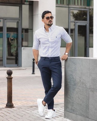 White and Black Vertical Striped Long Sleeve Shirt Outfits For Men: A white and black vertical striped long sleeve shirt and navy chinos are a cool combo worth having in your casual styling lineup. Add white canvas low top sneakers to the equation and you're all set looking boss.