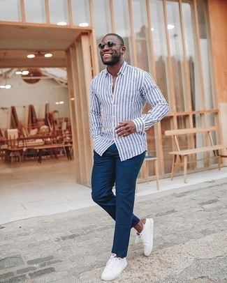 White and Navy Vertical Striped Long Sleeve Shirt Outfits For Men: A white and navy vertical striped long sleeve shirt and navy chinos teamed together are a perfect match. When not sure as to what to wear when it comes to shoes, stick to white canvas low top sneakers.