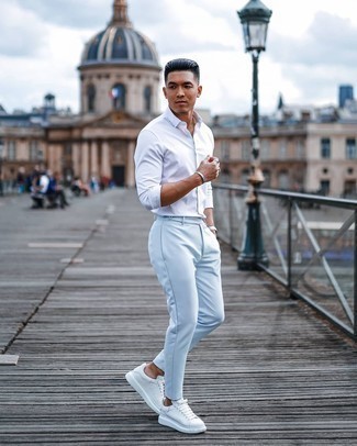 Light Blue Chinos Outfits: This pairing of a white long sleeve shirt and light blue chinos makes for the perfect base for a cool and casual look. White leather low top sneakers will bring a dose of stylish casualness to an otherwise classic ensemble.