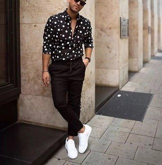 Black and White Polka Dot Long Sleeve Shirt Outfits For Men: This laid-back combo of a black and white polka dot long sleeve shirt and black chinos can go different ways according to how you style it out. A pair of white canvas low top sneakers will be a welcome accompaniment for your outfit.