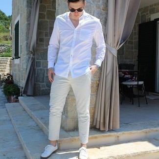 Charcoal Vertical Striped Chinos Outfits: This combination of a white long sleeve shirt and charcoal vertical striped chinos makes for the perfect foundation for a casually cool look. White canvas low top sneakers tie the ensemble together.
