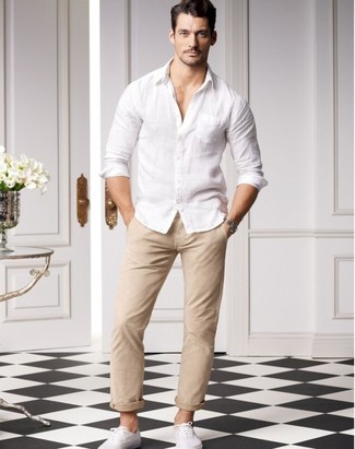 This relaxed combo of a white long sleeve shirt and beige chinos is super easy to throw together in next to no time, helping you look awesome and ready for anything without spending too much time rummaging through your wardrobe. Complement this look with white plimsolls and you're all done and looking boss.