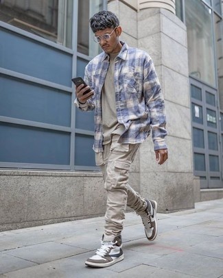 Beige Cargo Pants Outfits: Reach for a light blue gingham long sleeve shirt and beige cargo pants if you wish to look casually cool without too much effort. Let your sartorial prowess really shine by finishing your outfit with white and brown high top sneakers.