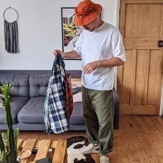 Orange Bucket Hat Outfits For Men: A multi colored plaid long sleeve shirt and an orange bucket hat are great menswear staples that will integrate perfectly within your off-duty wardrobe. Take your outfit in a dressier direction by wearing a pair of beige canvas slip-on sneakers.